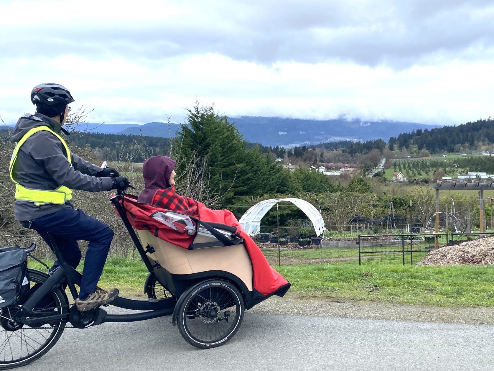 Trishaw passenger and pilot look out over farm fields on Wallace Drive.